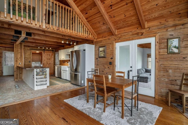 dining room featuring wood finished floors, french doors, wood ceiling, and wood walls