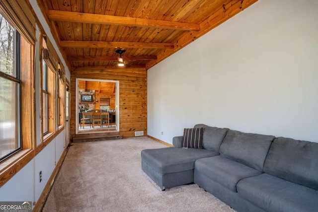 unfurnished living room with wooden walls, carpet, visible vents, lofted ceiling with beams, and wooden ceiling