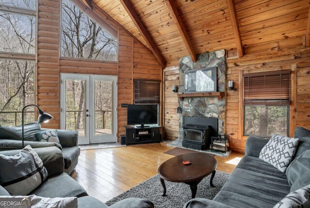 unfurnished living room featuring beamed ceiling, french doors, wood ceiling, and hardwood / wood-style floors