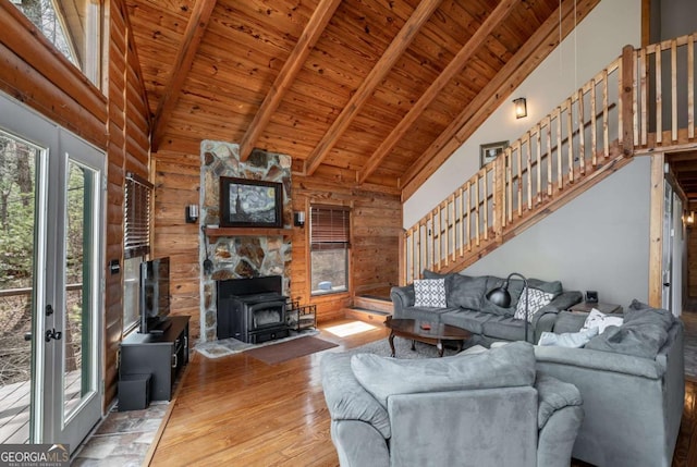 living area featuring wooden ceiling, a wood stove, and wood walls