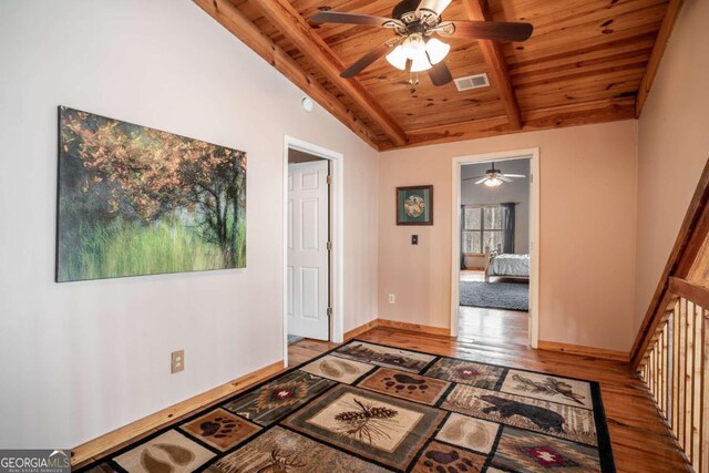 entryway featuring visible vents, vaulted ceiling with beams, baseboards, wooden ceiling, and wood finished floors