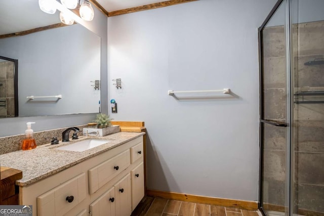 bathroom featuring a tile shower, vanity, baseboards, and wood finished floors