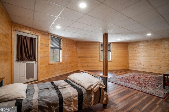 bedroom featuring wooden walls, recessed lighting, and wood finished floors