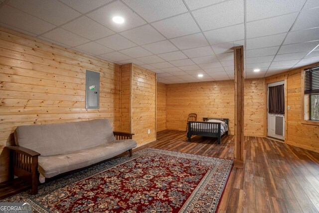 living room with electric panel, wood finished floors, recessed lighting, and wood walls