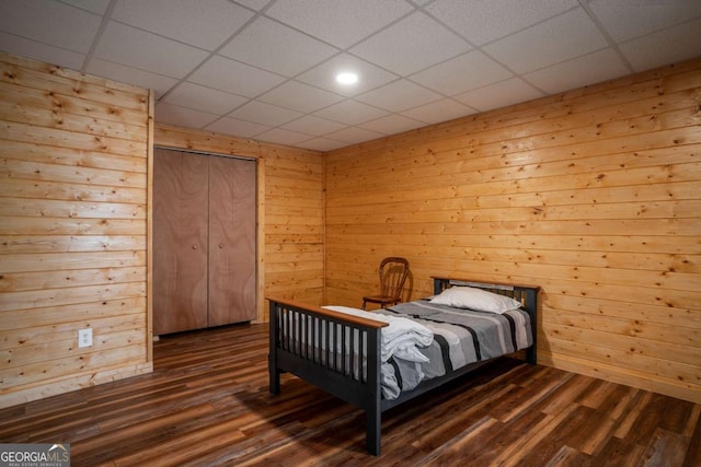 bedroom with dark wood finished floors and a drop ceiling