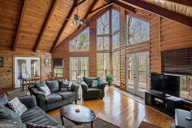 living area featuring log walls, french doors, wood-type flooring, wooden ceiling, and beamed ceiling