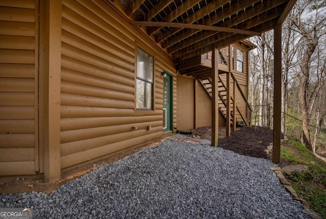 view of property exterior featuring stairs and faux log siding