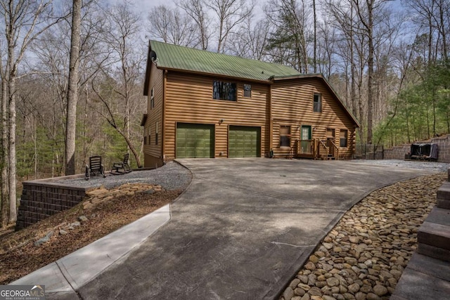 view of front of property with driveway, metal roof, and a garage