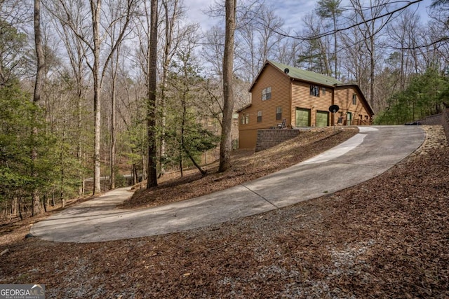 view of side of property featuring concrete driveway and a garage