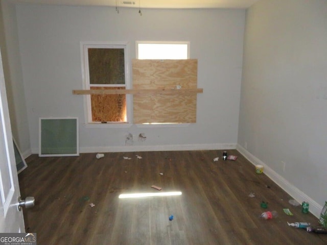 spare room featuring visible vents, baseboards, and wood finished floors