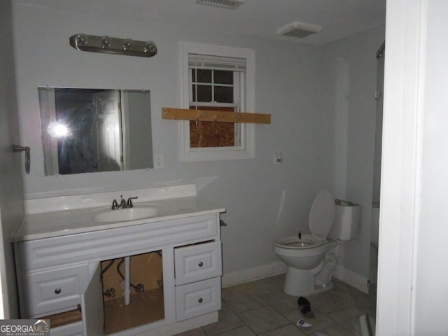 bathroom with vanity, toilet, and baseboards