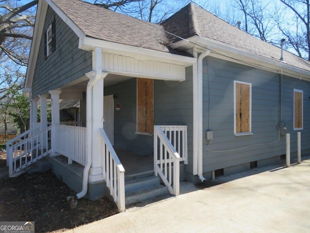 view of home's exterior featuring crawl space, covered porch, and roof with shingles