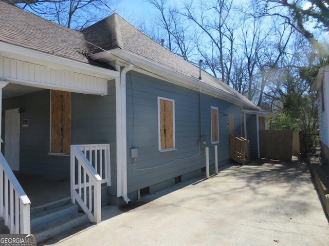 view of property exterior featuring crawl space and a shingled roof