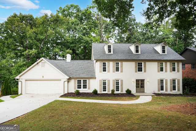 view of front of house featuring concrete driveway, a front lawn, a garage, and a shingled roof