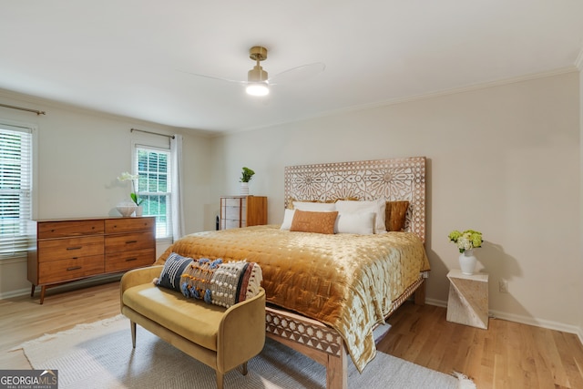 bedroom featuring ceiling fan, baseboards, light wood-style floors, and ornamental molding