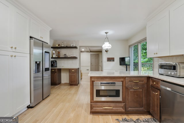 kitchen featuring a toaster, tasteful backsplash, appliances with stainless steel finishes, and light countertops