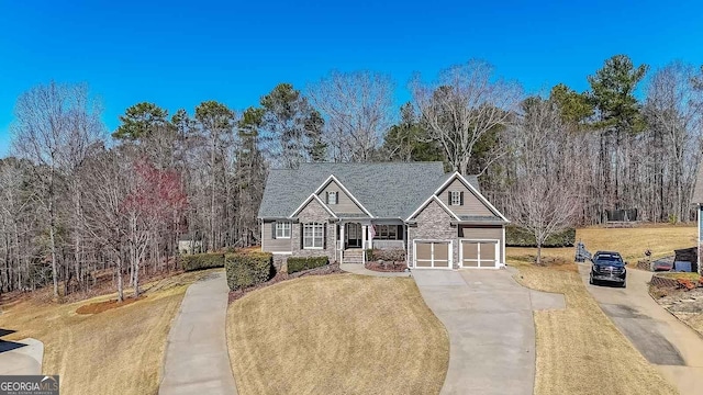 view of front of home with a front lawn, a garage, stone siding, and driveway