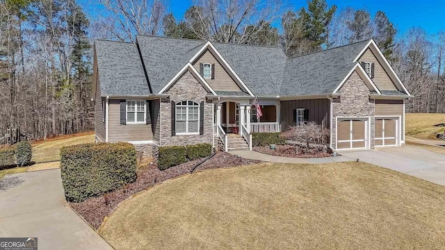 craftsman-style house with a front yard, driveway, covered porch, stone siding, and board and batten siding