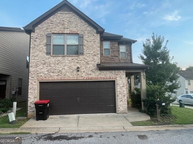 view of front facade featuring an attached garage, brick siding, and driveway