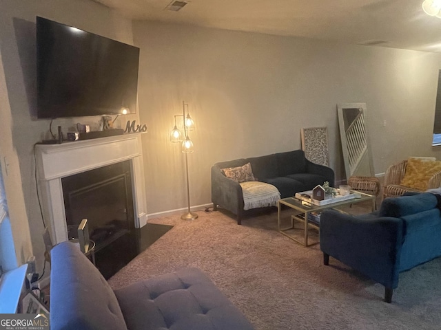 carpeted living room with a fireplace with flush hearth and visible vents