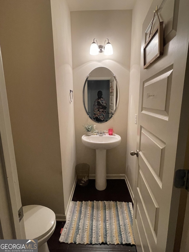 half bathroom with toilet and baseboards