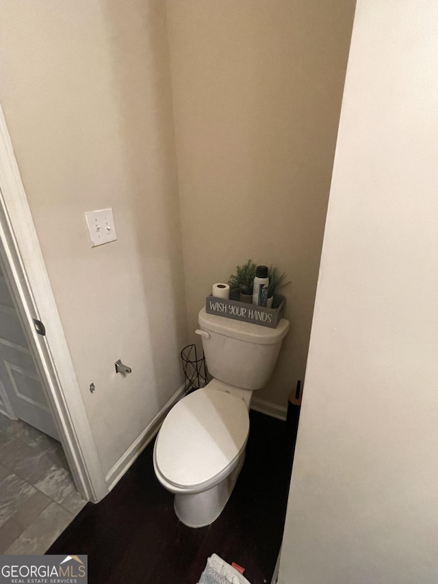 bathroom with toilet and baseboards