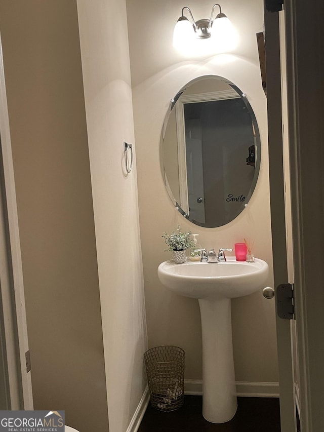 bathroom with a sink and baseboards
