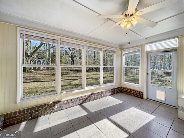 unfurnished sunroom featuring a wealth of natural light and a ceiling fan