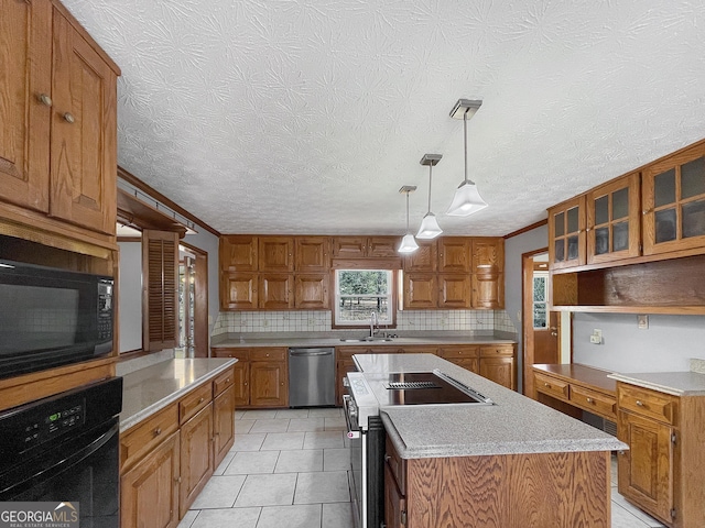 kitchen with decorative backsplash, black appliances, brown cabinets, and a center island with sink