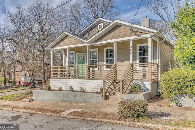bungalow-style home with covered porch and a chimney