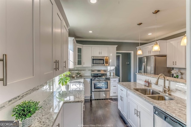 kitchen with dark wood-style floors, a sink, appliances with stainless steel finishes, white cabinetry, and backsplash