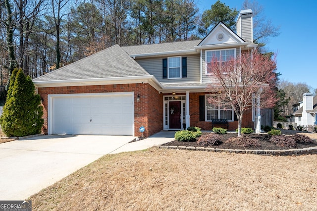 traditional-style home featuring roof with shingles, driveway, a chimney, a garage, and brick siding