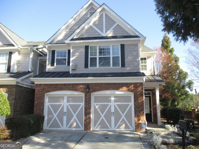 view of front of house with driveway, a standing seam roof, an attached garage, brick siding, and metal roof