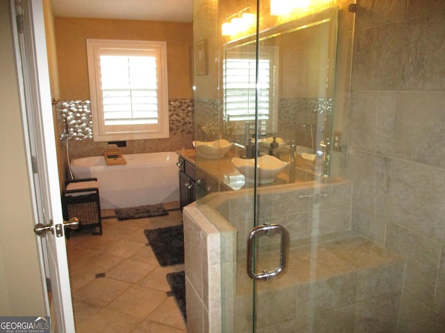 bathroom with tile patterned floors, plenty of natural light, a shower stall, and a freestanding bath