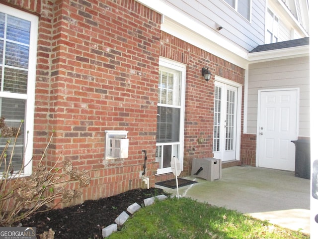 view of exterior entry featuring french doors and brick siding