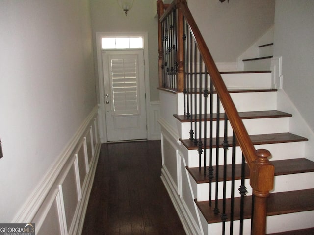 interior space with a decorative wall, a wainscoted wall, and wood finished floors