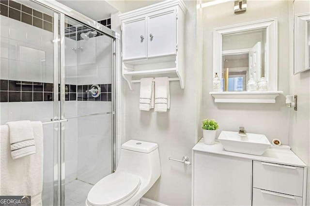 bathroom featuring a stall shower, toilet, and vanity