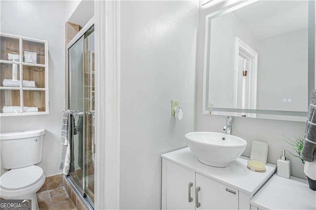 bathroom with a stall shower, toilet, and vanity