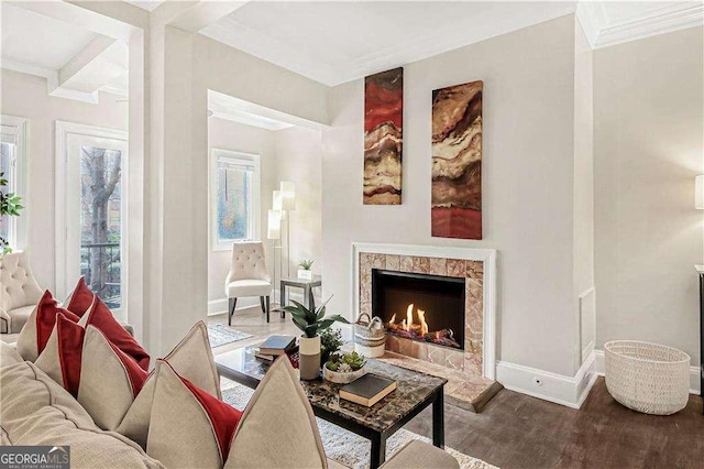 living area featuring visible vents, ornamental molding, wood finished floors, a fireplace, and baseboards