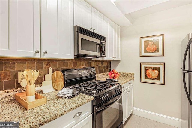 kitchen with white cabinetry, baseboards, backsplash, and stainless steel appliances