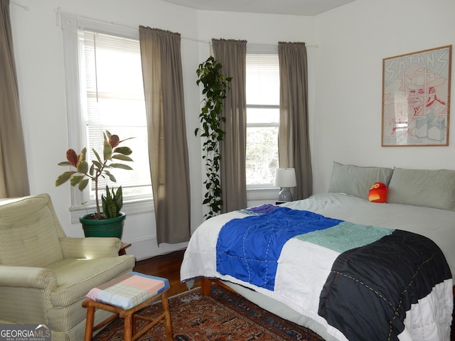 bedroom featuring multiple windows and dark wood-style flooring