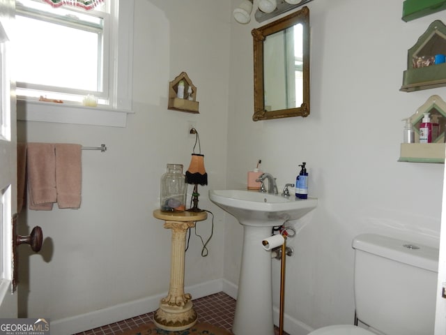 half bath with toilet and baseboards