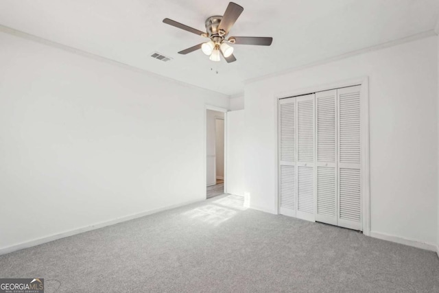 unfurnished bedroom featuring carpet, visible vents, baseboards, ceiling fan, and a closet