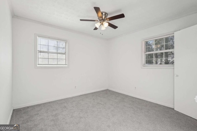 unfurnished room featuring ceiling fan, carpet flooring, baseboards, and ornamental molding