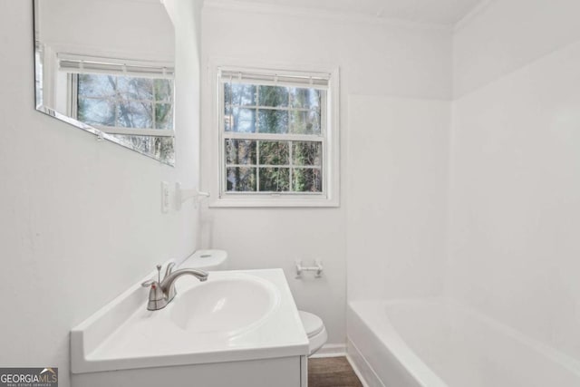 full bath featuring toilet, a healthy amount of sunlight, and vanity