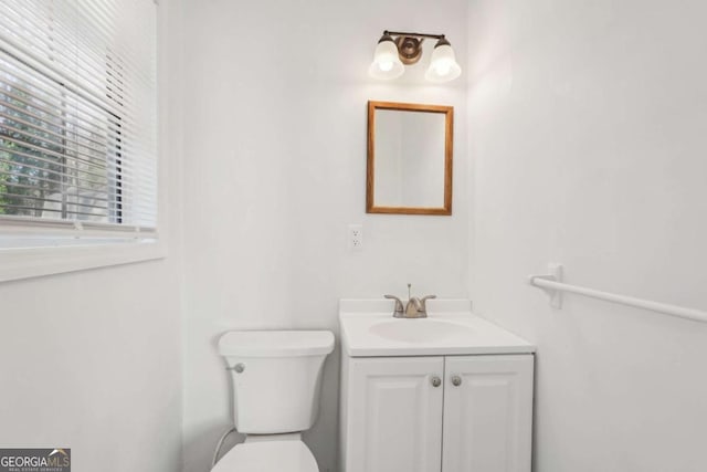 half bathroom with vanity and toilet