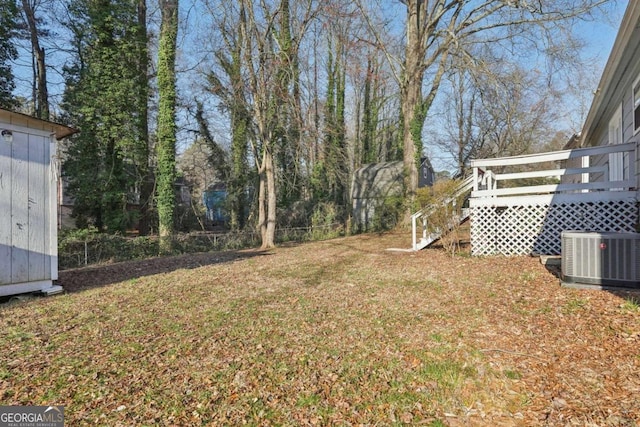 view of yard featuring a wooden deck, cooling unit, a storage shed, and an outdoor structure