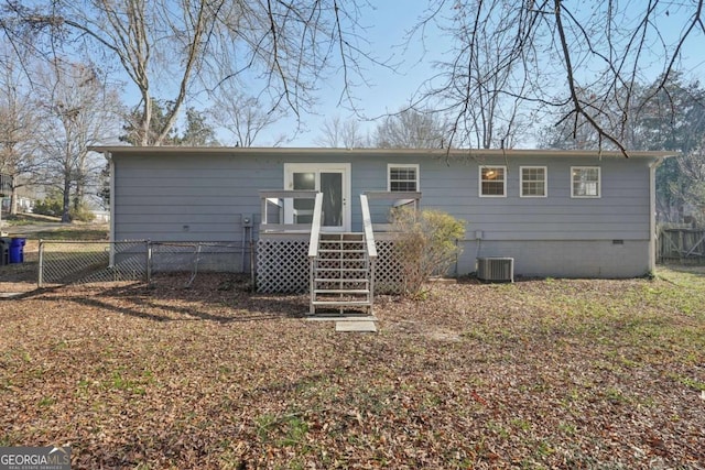 rear view of house with a deck, fence, central AC, and crawl space