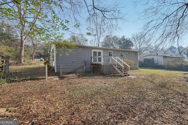 rear view of property with stairs, a deck, and fence