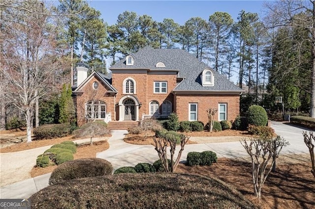 view of front of home with brick siding and a shingled roof